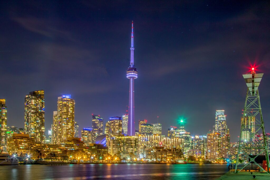 toronto skyline view at night with a water reflection of city lights
